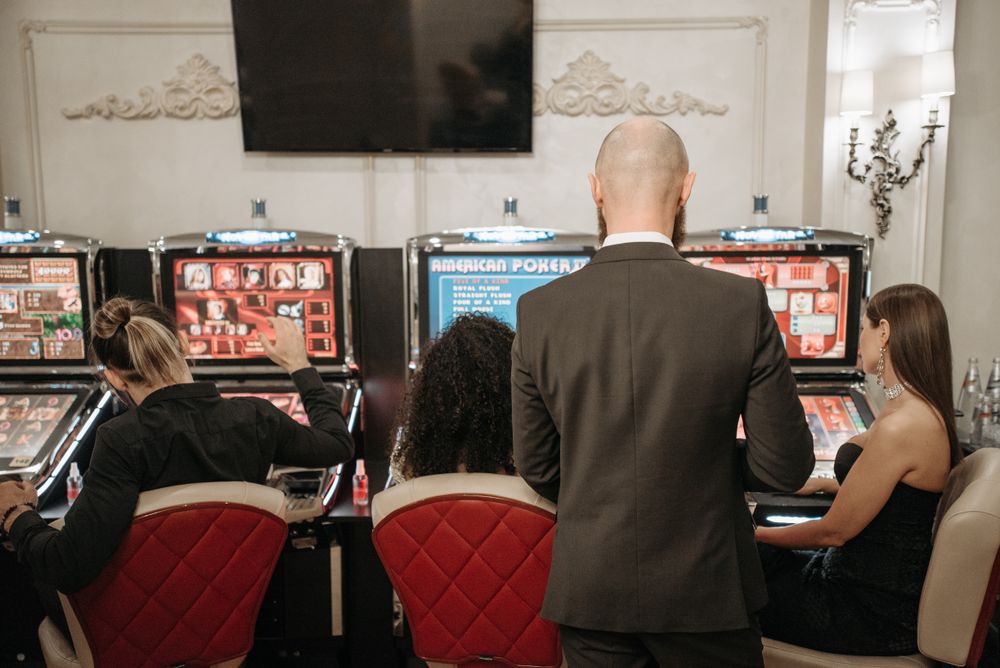 Sekelompok pemain dewasa di depan meja roulette kasino
