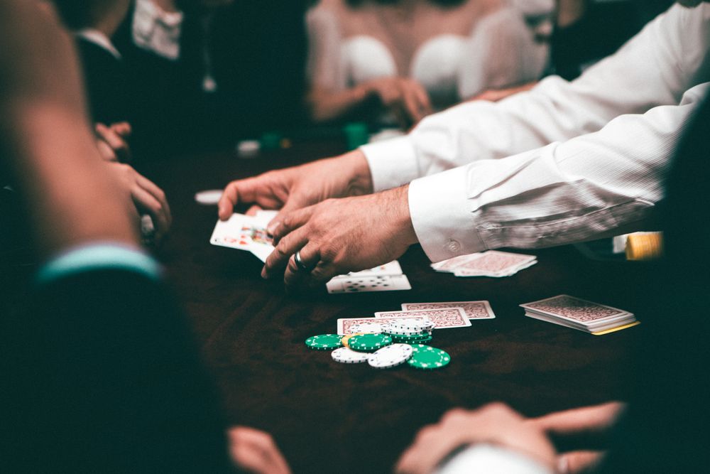 Pemain poker memegang kartu remi di atas meja