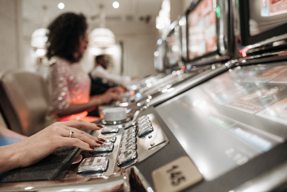Tangan pemain menekan tombol spin pada mesin slot